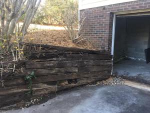 collapsing driveway timber retaining wall before Parks' Masonry repair