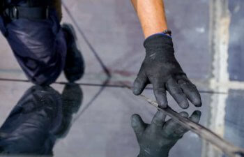 a worker checking joint sealant of glass curtain wall