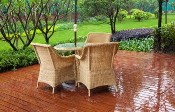 Backyard patio with garden furniture in rain.